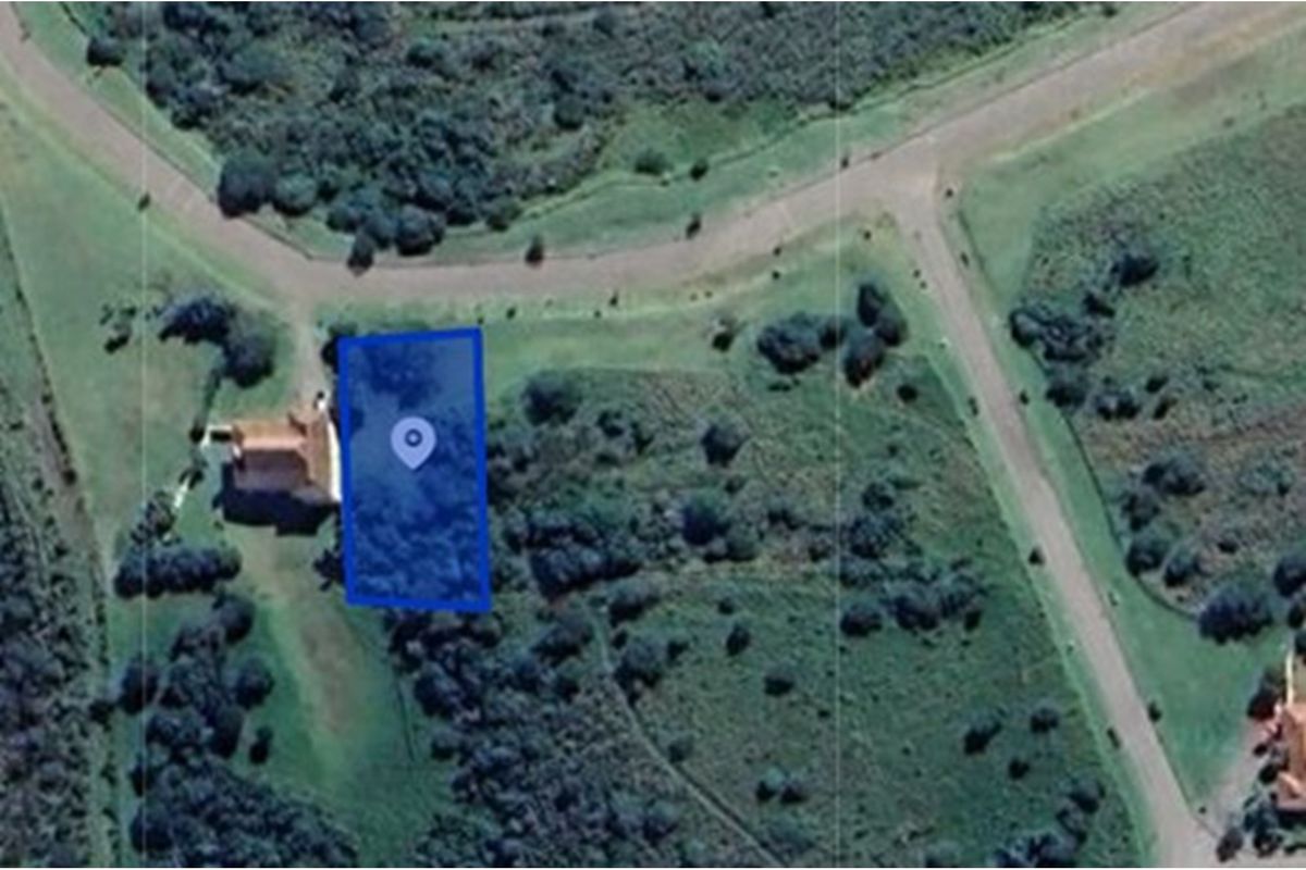 An aerial view of a vacant residential plot highlighted in blue, situated within a landscaped estate environment.