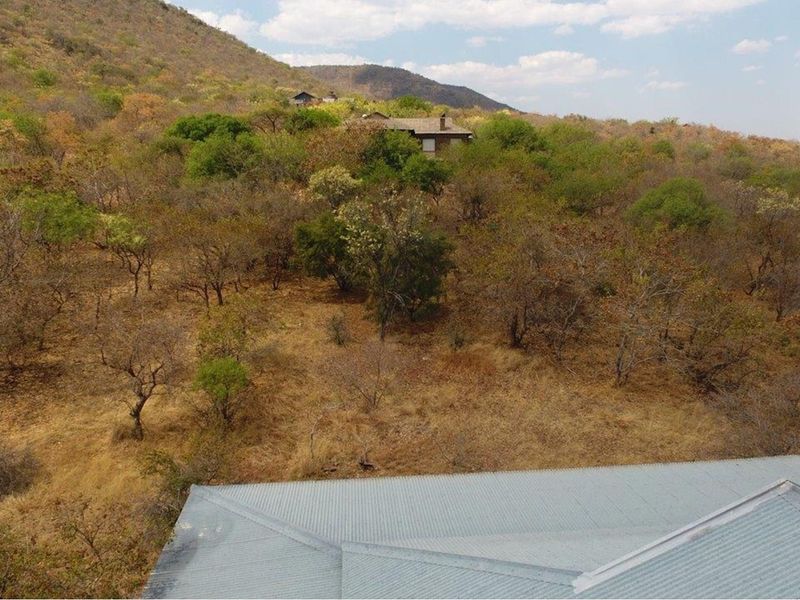 Elevated view overlooking the surrounding natural bushveld landscape and hillside terrain from the property roofline.
