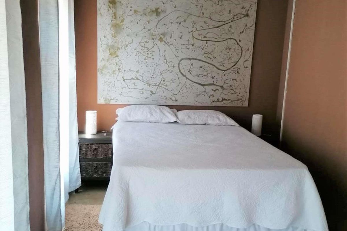 A bedroom featuring neutral-toned walls and natural light from the adjacent window.