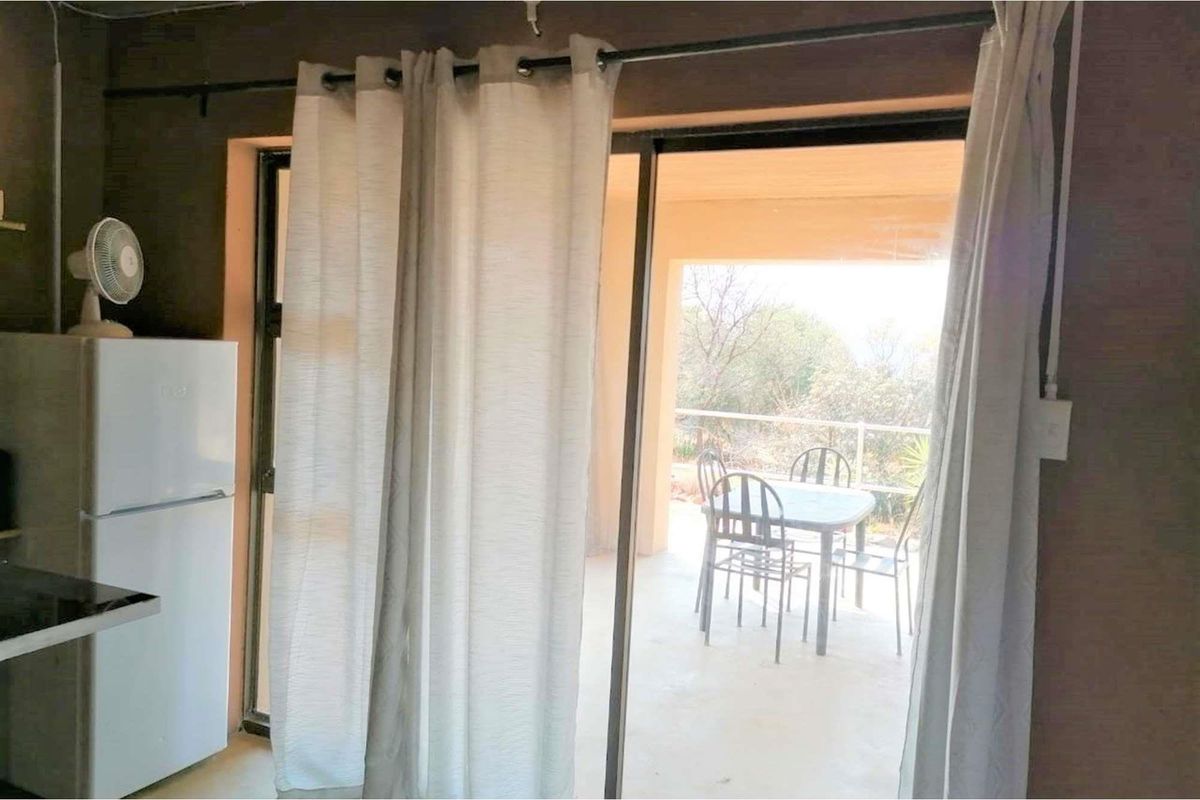 Interior view showing a kitchen area with sliding glass doors leading to a covered patio space.