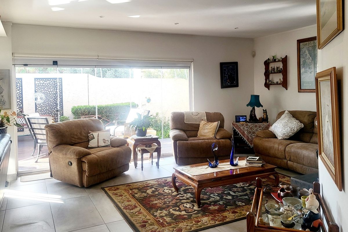 Spacious living room featuring large sliding glass doors that provide seamless access to the outdoor patio area.