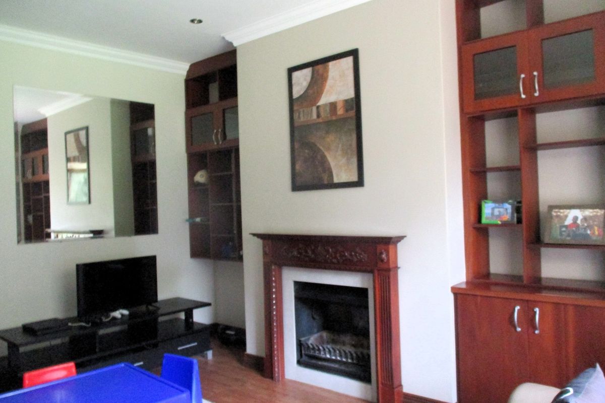 Living room featuring a traditional wooden fireplace mantel, built-in cabinetry, and recessed ceiling lighting.