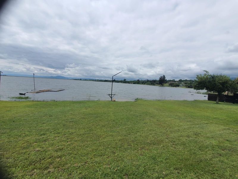 Expansive waterfront lawn area offering direct access to the lake, featuring a natural landscape and open outdoor space.