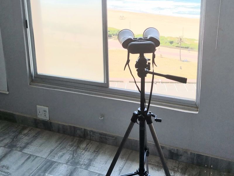 A bright interior space featuring large sliding windows with a direct view of the beach and coastline.