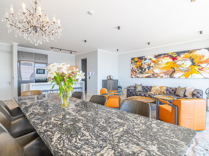 Spacious open-plan living and dining area featuring a modern kitchen with integrated appliances, high-end finishes, and elegant lighting throughout.