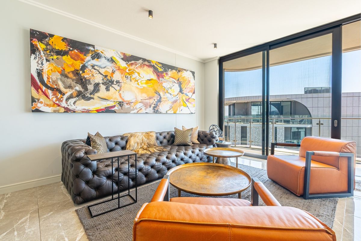 Modern living room featuring large sliding glass doors leading to a balcony, stone tile flooring, and recessed ceiling lighting.