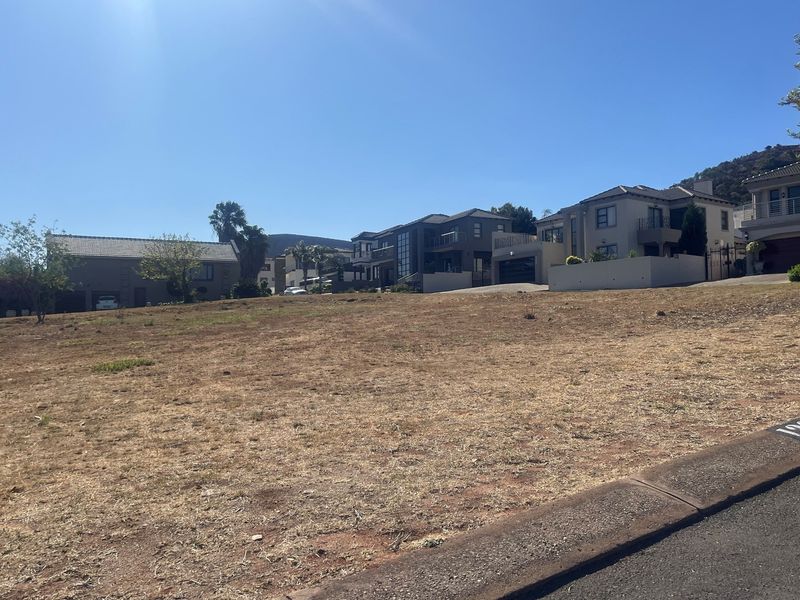 A vacant residential plot situated in a developed neighbourhood, offering a clear building site with established surrounding homes.