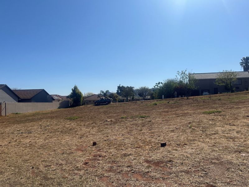 A vacant residential plot of land featuring a gentle slope, clear boundaries, and surrounding established residential properties.