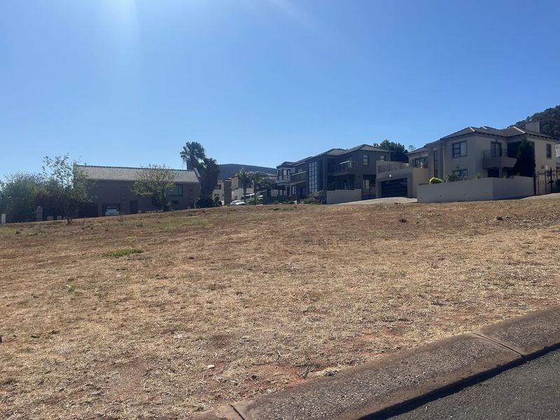 A vacant residential plot of land situated in an established neighborhood, offering a clear building site with surrounding residential properties.
