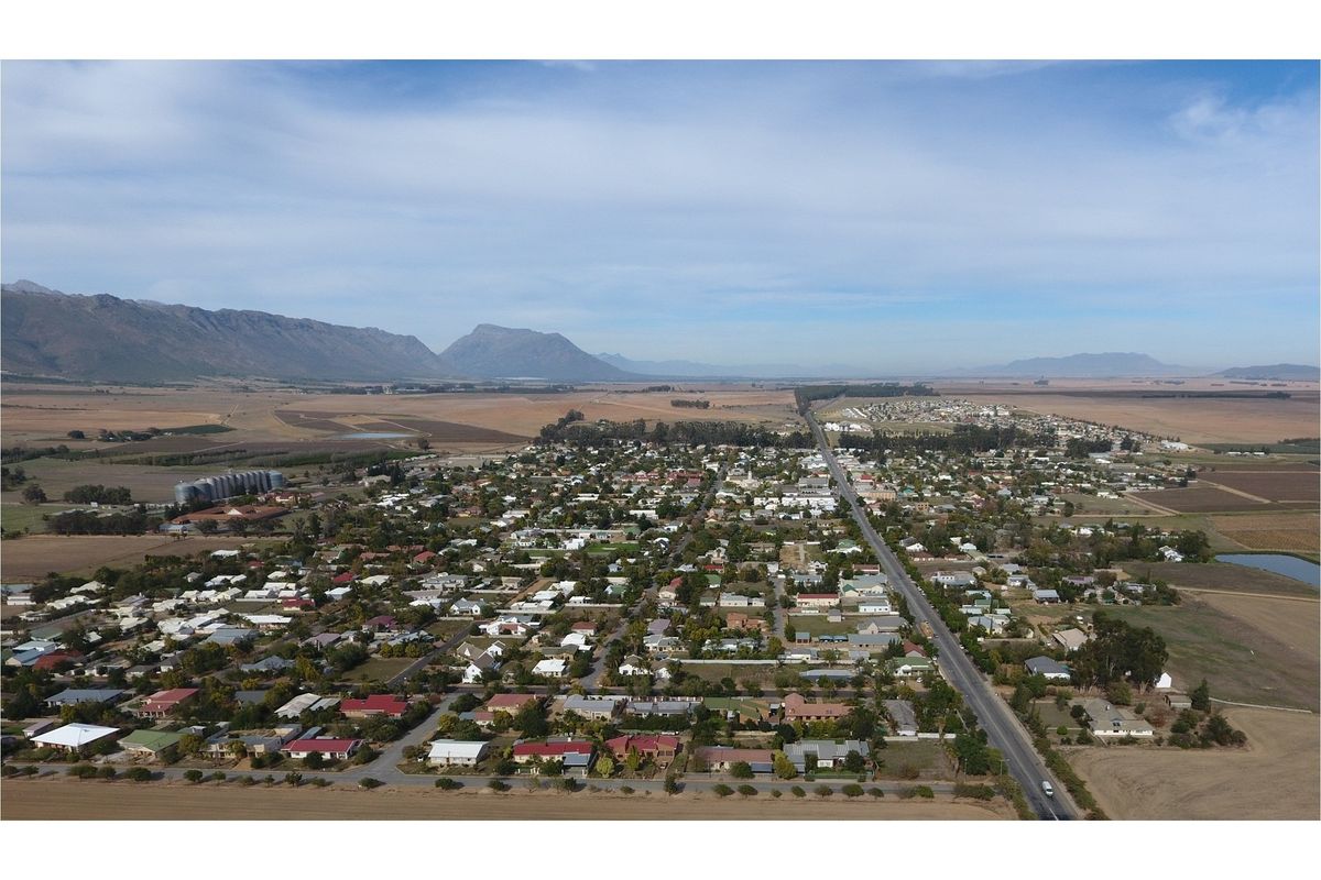 An aerial view of the lodge location, showcasing the surrounding town, landscape, and mountain range in the distance.