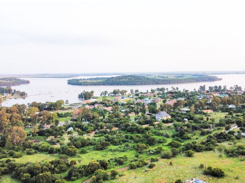 An elevated aerial view showcasing the surrounding landscape, lush greenery, and proximity to the waterfront.