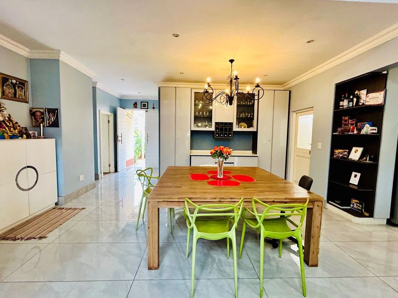 Spacious dining area featuring polished floor tiles, recessed ceiling lighting, and built-in cabinetry with integrated display shelving.