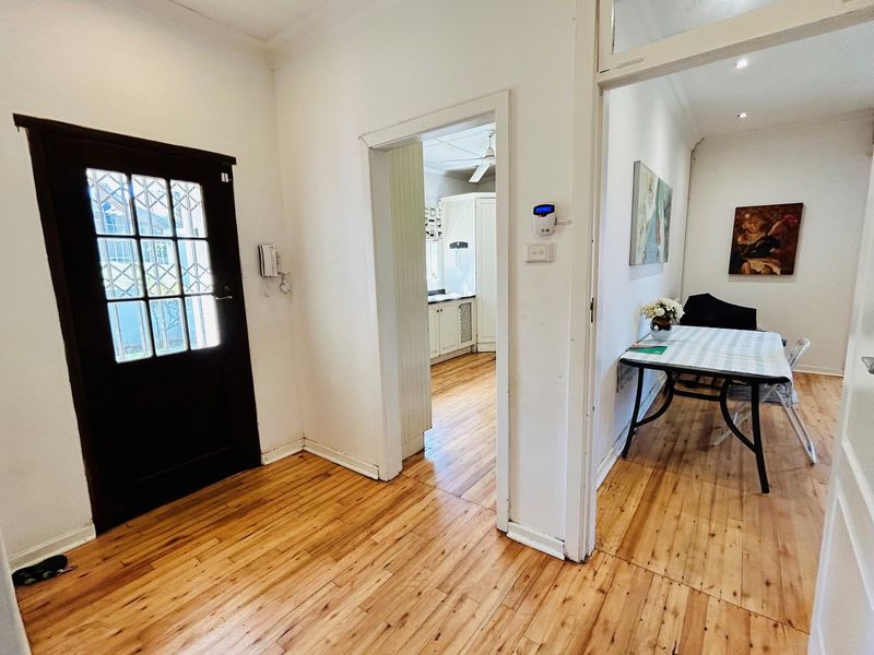 Entrance foyer featuring polished timber flooring, providing access to the kitchen and adjacent living area.