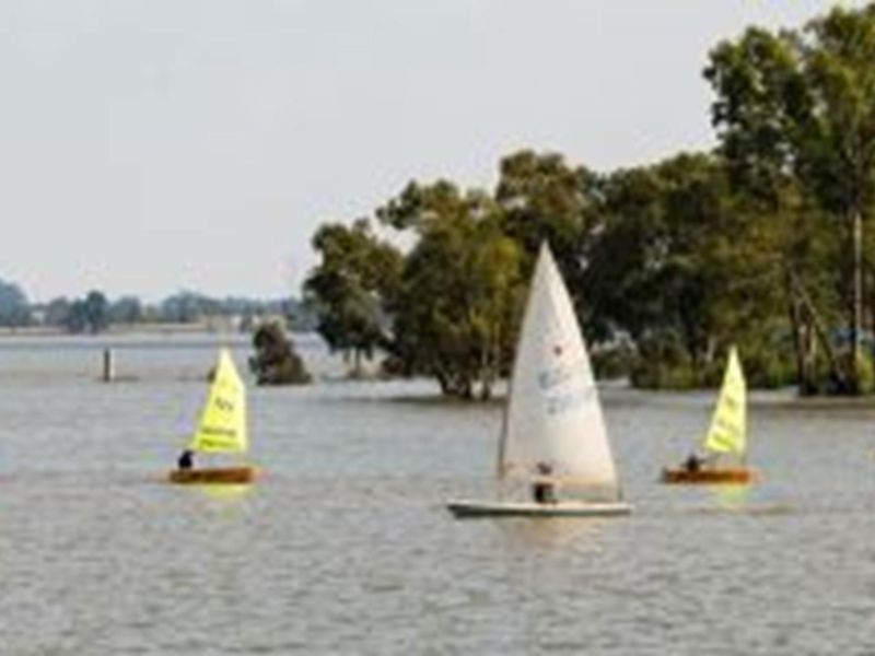 A scenic view of a lake featuring sailboats on the water, highlighting the natural landscape and recreational potential of the area.