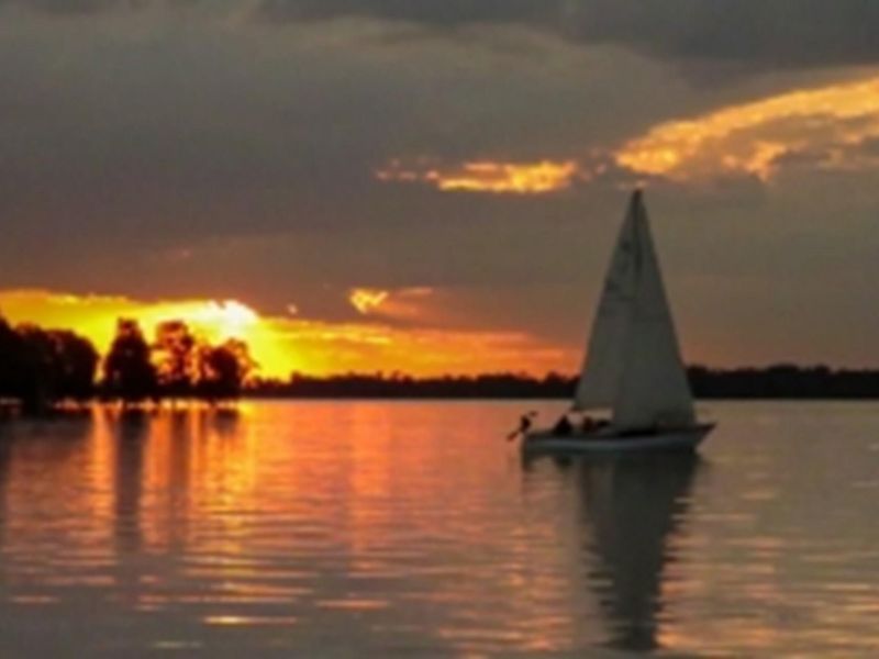 A scenic sunset view over the water, showcasing the natural landscape and tranquil atmosphere of the surrounding area.