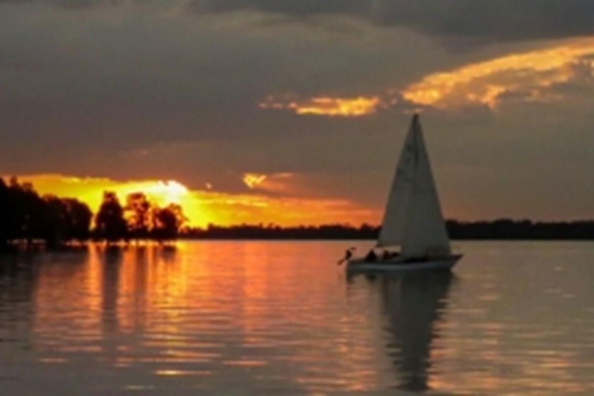 A scenic sunset view over the water, showcasing the natural landscape and tranquil atmosphere of the surrounding area.