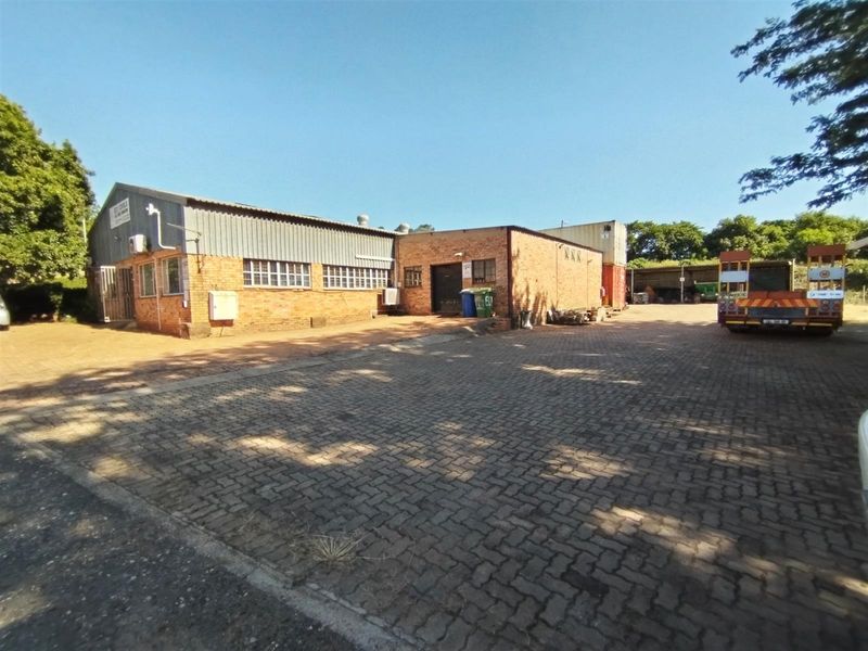 Industrial property featuring a brick and metal-clad warehouse building with a paved yard area, suitable for logistics or manufacturing operations.