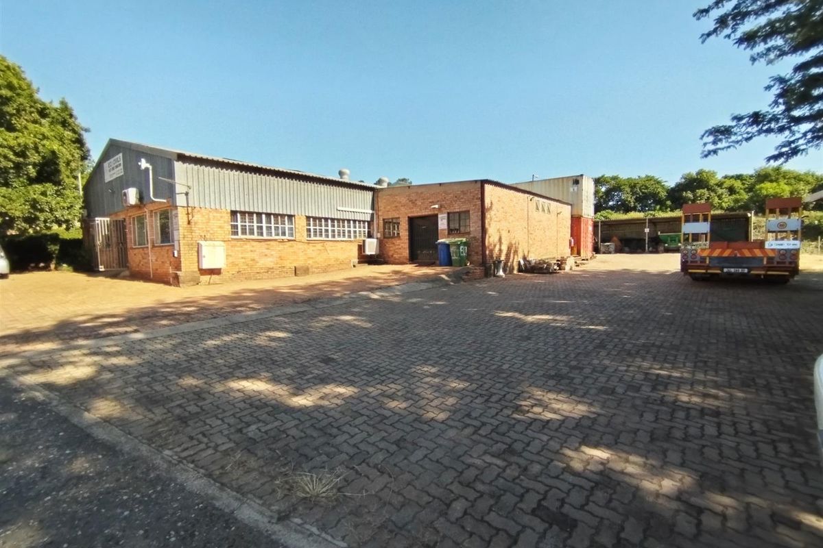 Industrial property featuring a brick and metal-clad warehouse building with a paved yard area, suitable for logistics or manufacturing operations.