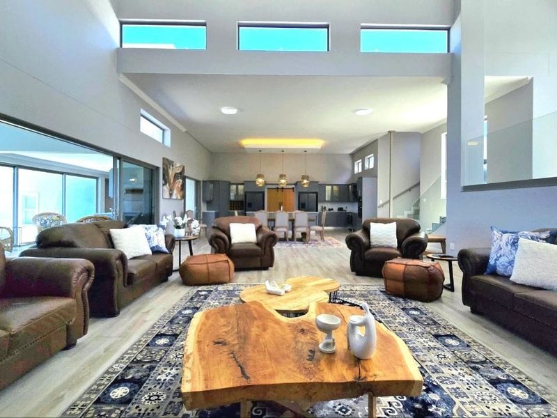 Spacious open-plan living and dining area featuring high ceilings, clerestory windows, and large sliding glass doors leading to an outdoor space.