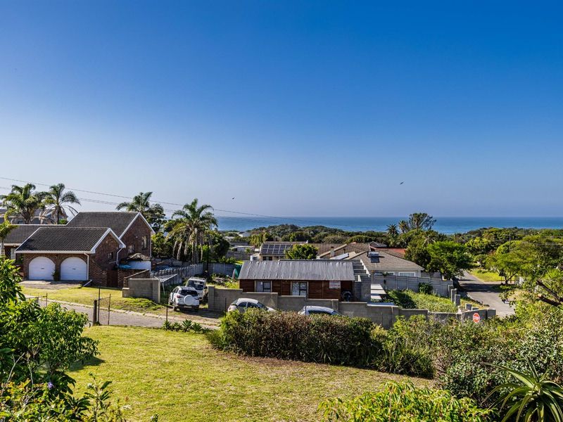 Elevated view overlooking the surrounding residential neighbourhood with a clear horizon line and ocean vista in the distance.