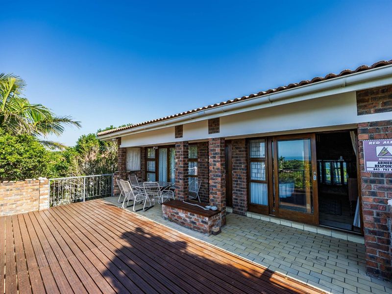 Spacious outdoor patio featuring timber decking, brick pillars, and sliding glass doors, offering a seamless transition between indoor and outdoor living spaces.