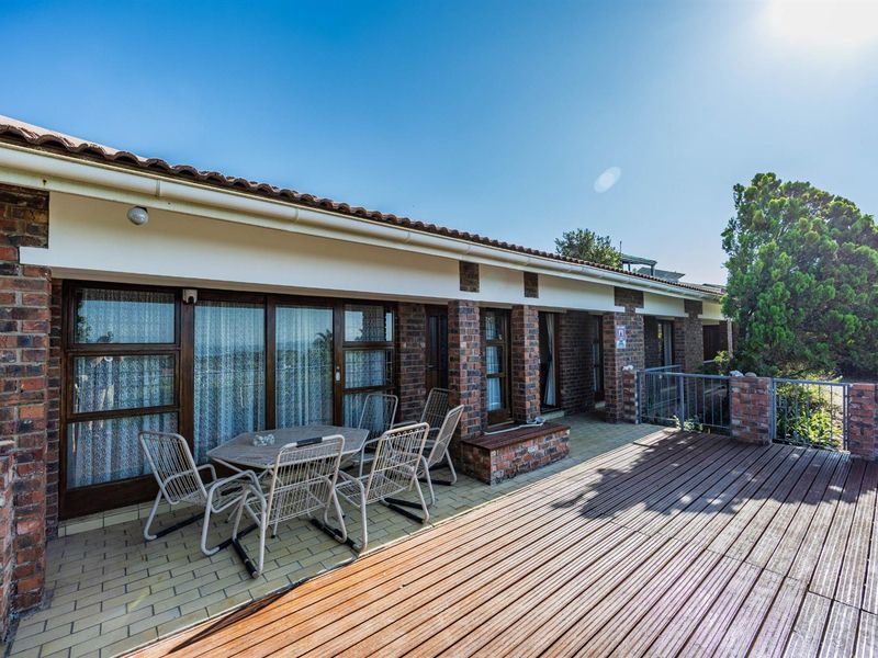 Spacious outdoor patio featuring a combination of tiled flooring and timber decking, with direct access to the home through sliding glass doors.