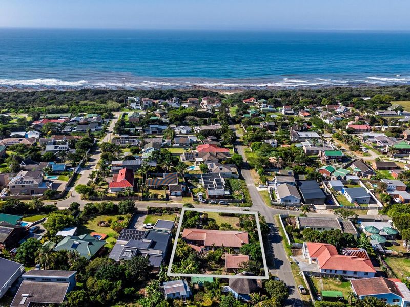 Aerial view of a residential property located in a coastal neighborhood, highlighting the building footprint and surrounding landscape.