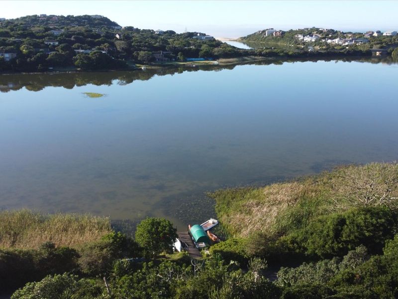 An elevated aerial view overlooking a serene lagoon, showcasing the natural landscape and surrounding coastal vegetation.
