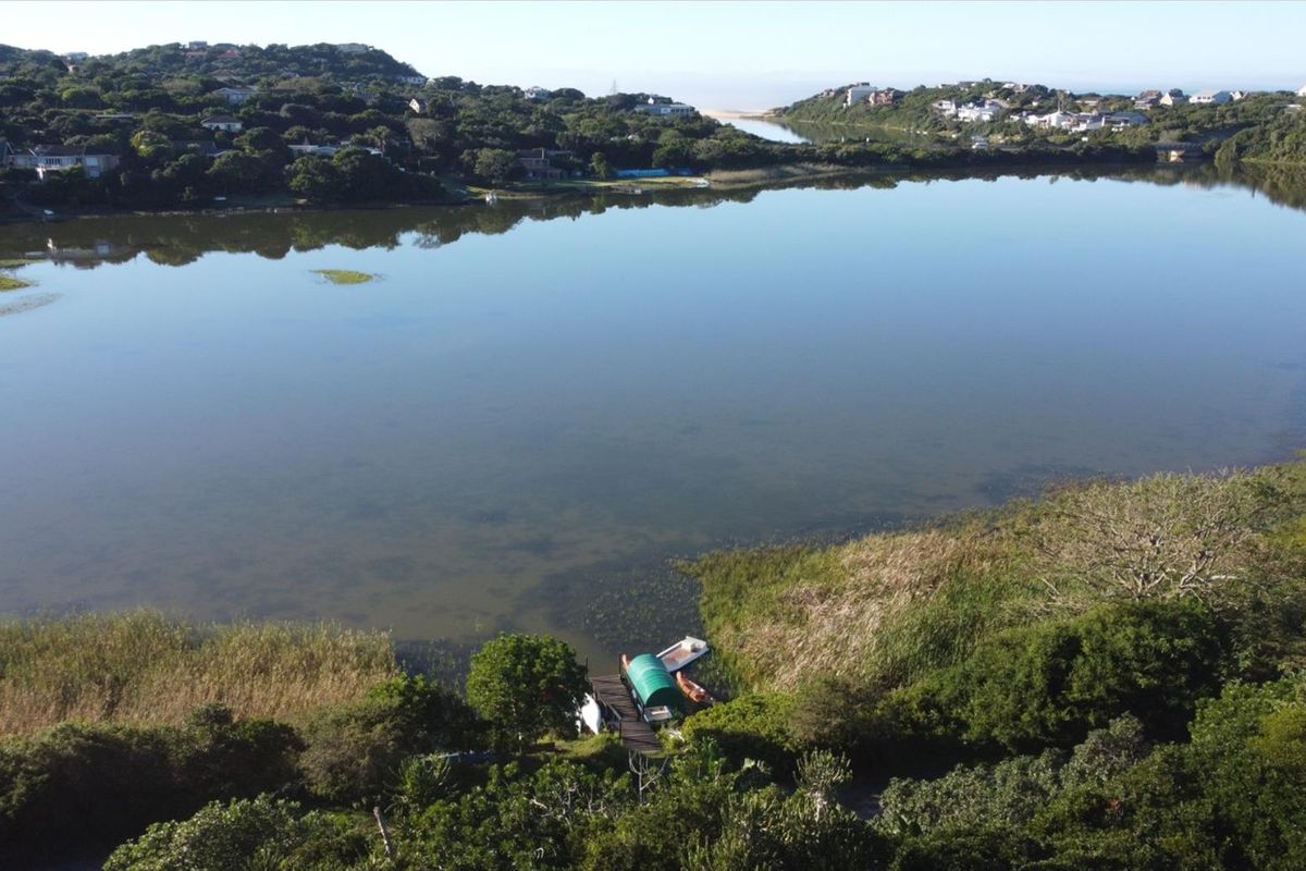 An elevated aerial view overlooking a serene lagoon, showcasing the natural landscape and surrounding coastal vegetation.