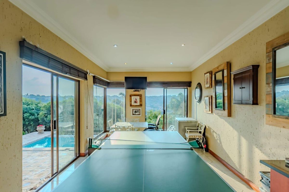 Spacious living area featuring large sliding glass doors that open to a pool deck, offering expansive views and abundant natural light.