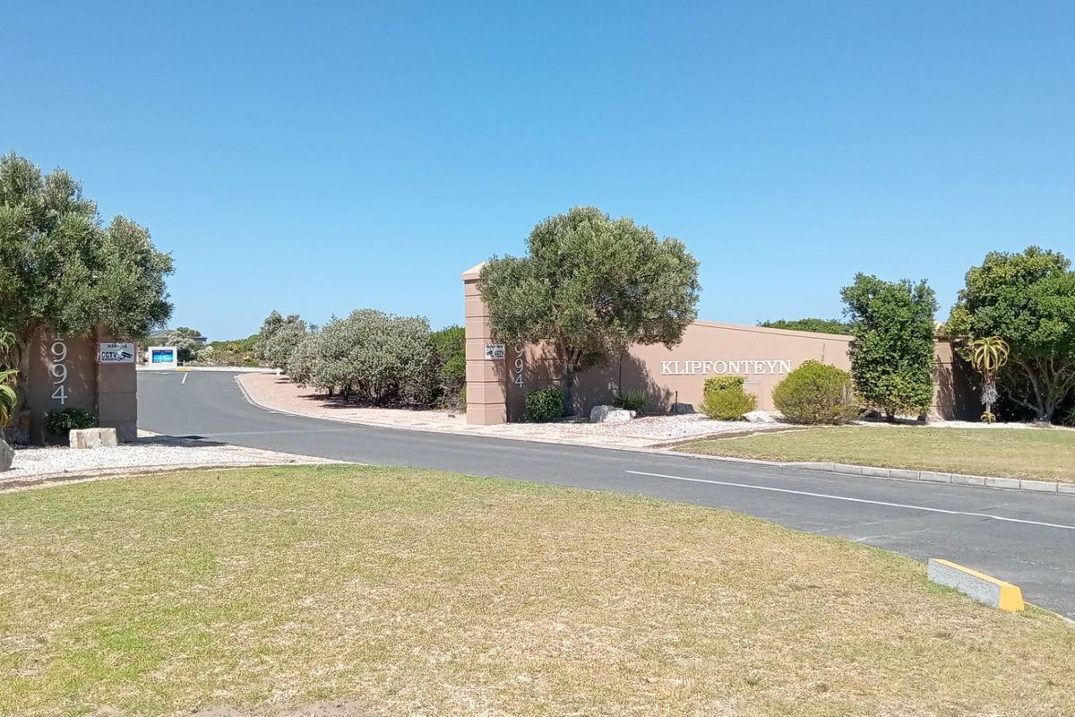 Entrance view of Klipfonteyn residential estate featuring paved access road, boundary walls, and established landscaping.