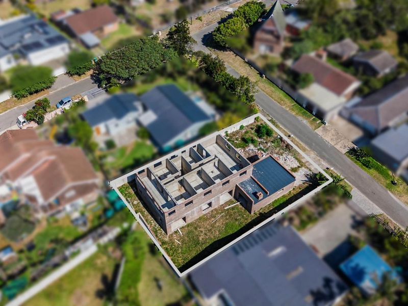 Aerial view of a residential property currently under construction, showing the brick shell and layout of the building on the plot.