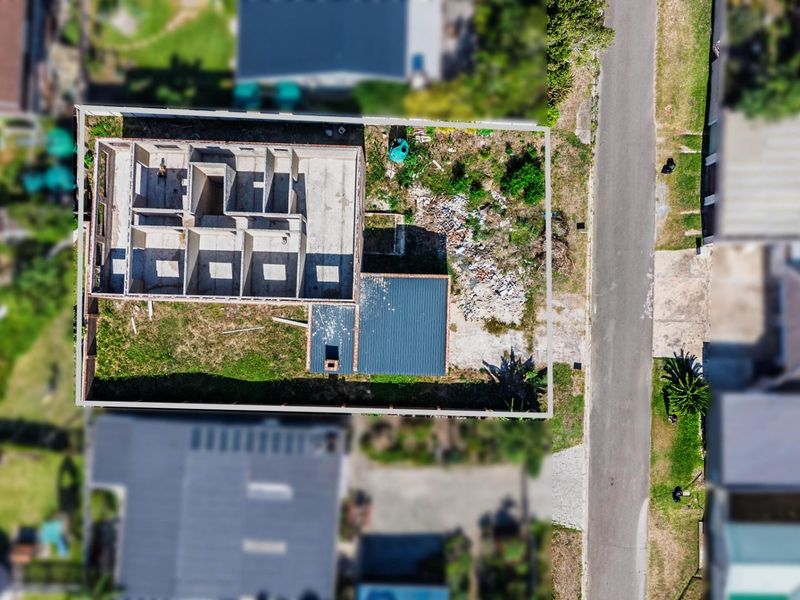 Aerial view of a residential property under construction, showing the building footprint, concrete structure, and surrounding plot.