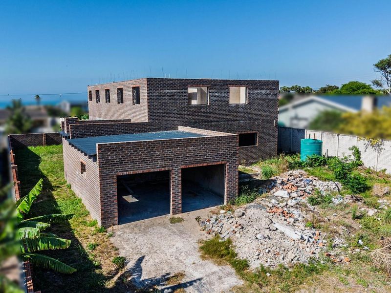 Aerial view of a residential property under construction, featuring a double garage and multi-level brick structure on a large plot.