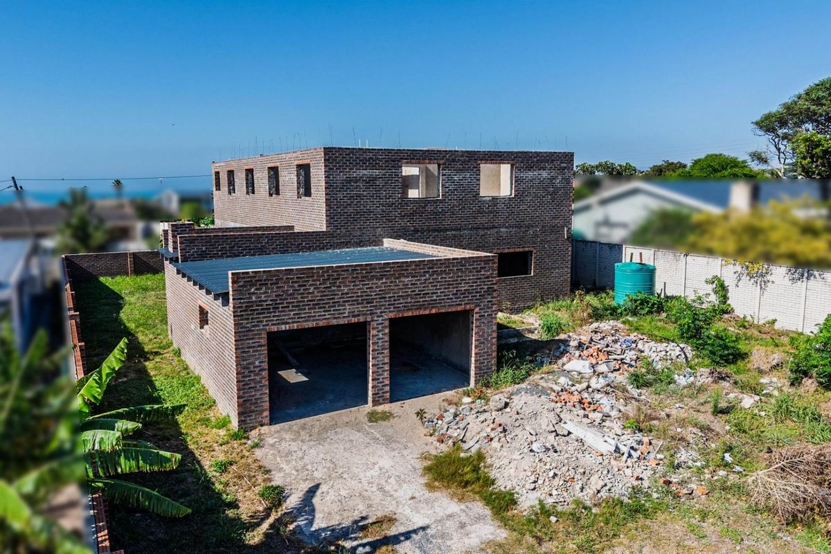 Aerial view of a residential property under construction, featuring a double garage and multi-level brick structure on a large plot.