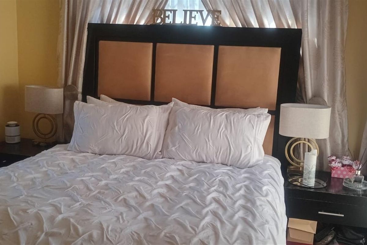 A bedroom featuring neutral wall tones and window treatments, providing a comfortable and functional sleeping space.