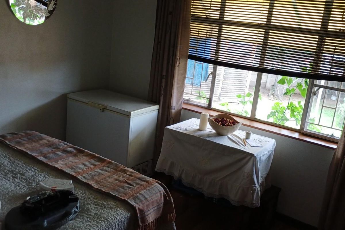 A bedroom featuring a window with fitted blinds, providing natural light and a view of the exterior.