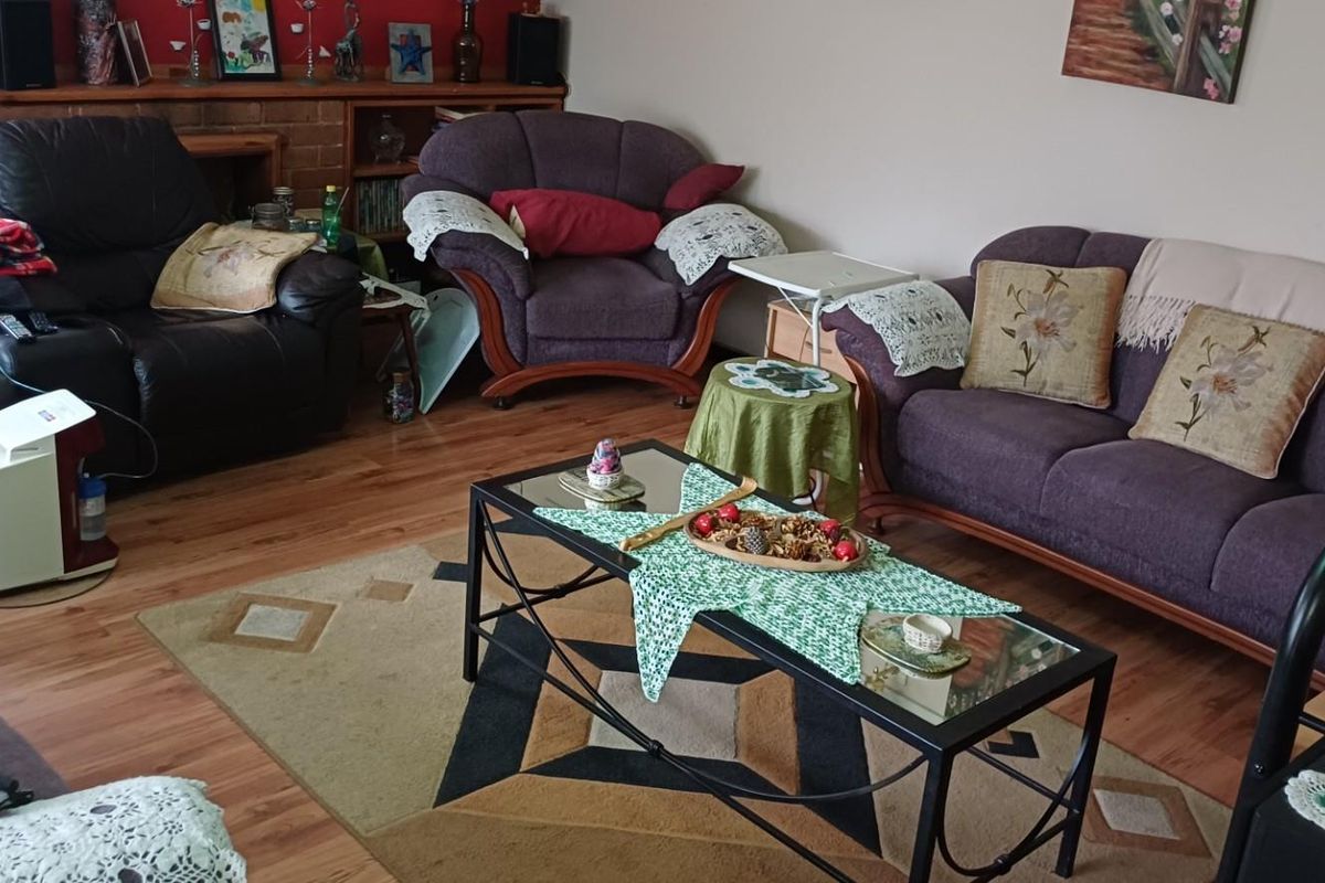 A comfortable living room featuring laminate wood flooring and a built-in brick fireplace surround.