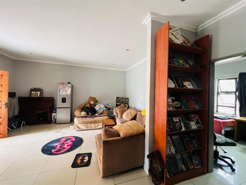 Open plan living area featuring tiled flooring, recessed ceiling lighting, and crown molding, providing a versatile space for relaxation and daily living.