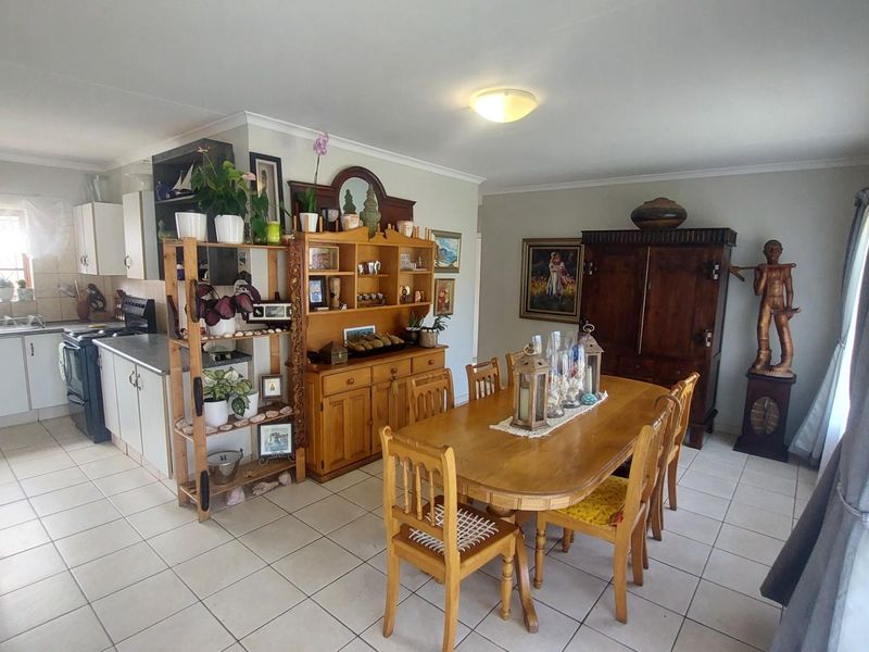 Open plan kitchen and dining area featuring tiled flooring, white cabinetry, and a functional layout suitable for family living.