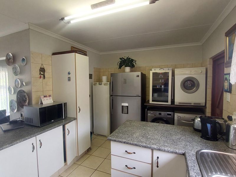 Functional kitchen featuring granite countertops, tiled splashbacks, and ample built-in cabinetry with space for multiple appliances.