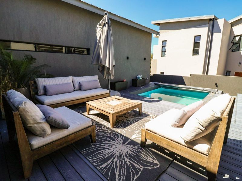 Outdoor entertainment area featuring a swimming pool with a cover and timber decking, perfect for relaxation and social gatherings.