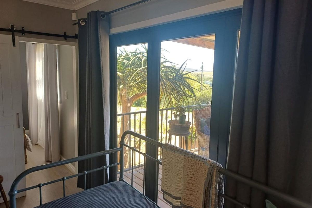 Bedroom featuring sliding glass doors that open onto a private balcony, providing natural light and outdoor access.