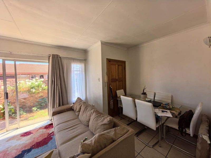 Open plan living and dining area featuring tiled flooring and sliding glass doors providing direct access to the rear garden.