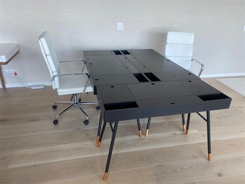 A modern office space featuring light-toned laminate flooring and neutral wall finishes, providing a clean and professional environment.