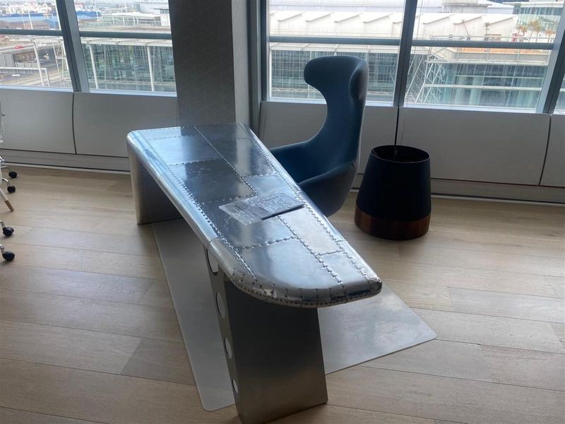 Modern office space featuring floor-to-ceiling windows with expansive city views and high-quality timber flooring.
