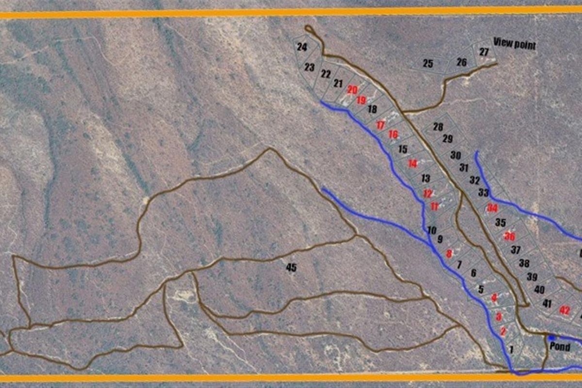 An aerial site plan showing the layout of the property, including numbered plots, access roads, a dam, a pond, and the main farmhouse location.