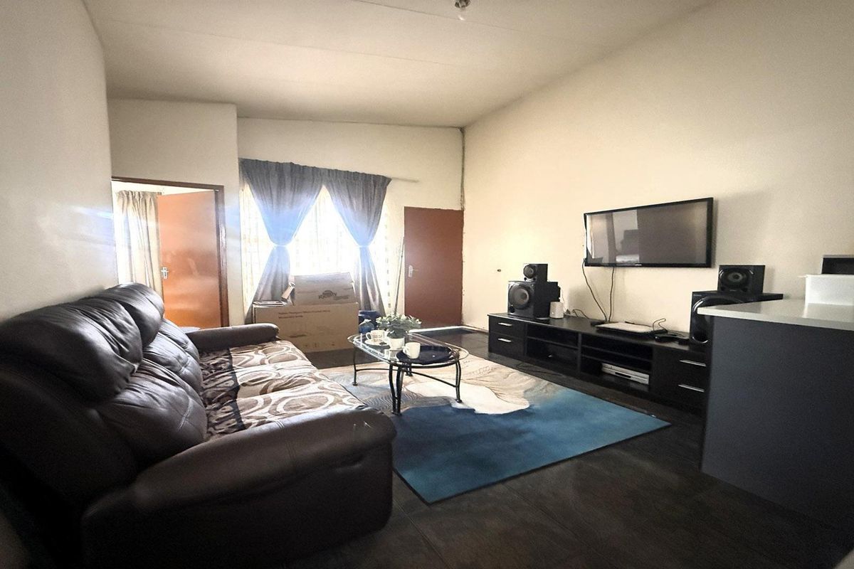 A functional living room area featuring tiled flooring and neutral wall finishes, providing a versatile space for relaxation.