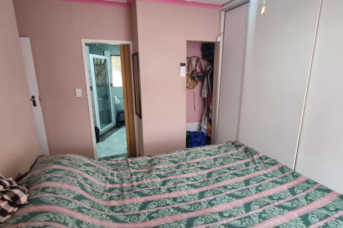 A bedroom featuring built-in sliding door wardrobes and direct access to an en-suite bathroom.