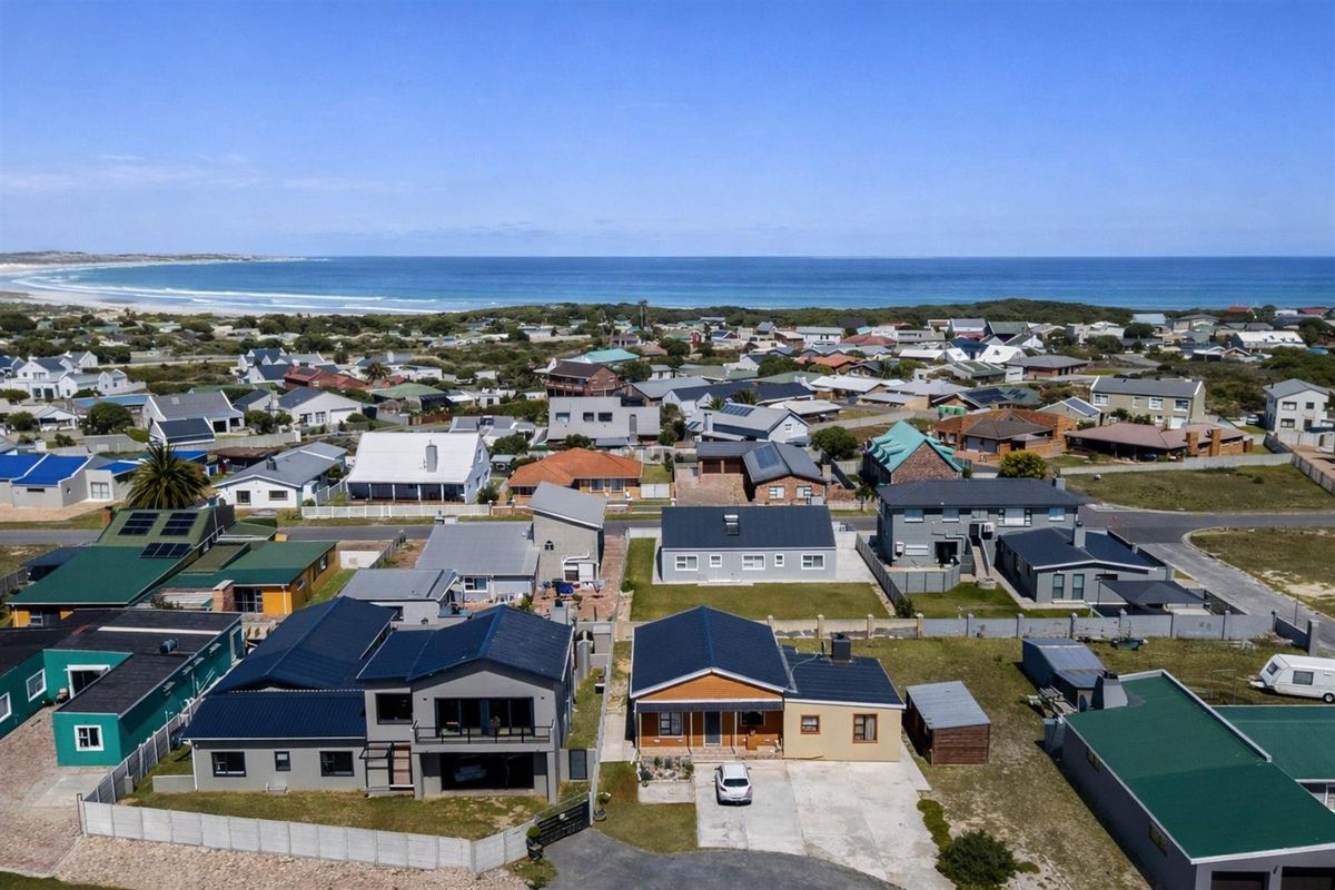 Aerial view of the coastal residential neighborhood, showcasing the property's location relative to the nearby beach and surrounding homes.
